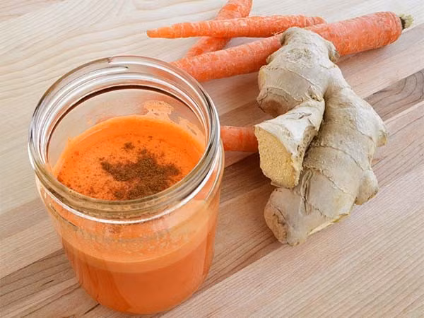 Nước ép cà rốt. Chuẩn bị 4-5 củ cà rốt, ½ củ gừng, ½ quả chanh, bột quế, muối biển. Cà rốt gọt vỏ, rửa sạch và để ráo nước. Gừng gọt bỏ vỏ và rửa kỹ và bỏ 2 nguyên liệu này vào máy xay sinh tố xay nhỏ. Dùng dụng cụ lọc lấy nước sinh tố, đổ ra cốc và vắt nửa quả chanh vào. Ảnh: Tamsutre.