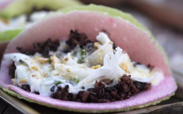 Hấp chín đậu xanh không vỏ, nghiền nhuyễn, thêm đường trắng, trộn đều. Nếp than ngâm nước khoảng 3 giờ hoặc qua đêm cho mềm. Trộn đều nếp than với muối, cho vào xửng hấp, hấp chín. Hành lá rửa sạch, cắt nhỏ, cho vào chảo với 1/3 chén dầu ăn, đảo đều khoảng 30 giây để làm mỡ hành. Mè trắng rang qua cho thơm. Ảnh: Cooky.vn.