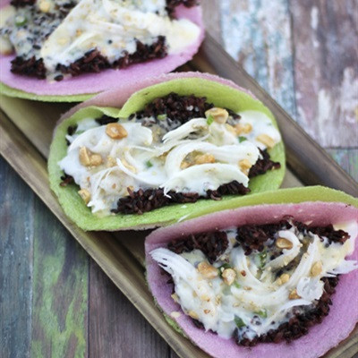 Giã nhỏ đậu phộng, mè trắng, thêm đường trắng vào, trộn đều. Cho nước cốt dừa, đường trắng còn lại, bột bắp vào nồi, bắc lên bếp, khuấy đều khoảng 4 phút để đường trắng tan hết. Cho xôi vào bánh tráng, dàn mỏng. Tiếp đến là hỗn hợp đậu xanh không vỏ, hỗn hợp nước cốt dừa, dừa nạo lên trên. Rắc đậu phộng, mè trắng, chan đều mỡ hành và thưởng thức. Ảnh: Cooky.vn.