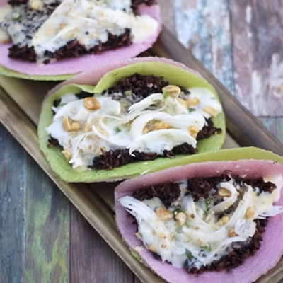 Giã nhỏ đậu phộng, mè trắng, thêm đường trắng vào, trộn đều. Cho nước cốt dừa, đường trắng còn lại, bột bắp vào nồi, bắc lên bếp, khuấy đều khoảng 4 phút để đường trắng tan hết. Cho xôi vào bánh tráng, dàn mỏng. Tiếp đến là hỗn hợp đậu xanh không vỏ, hỗn hợp nước cốt dừa, dừa nạo lên trên. Rắc đậu phộng, mè trắng, chan đều mỡ hành và thưởng thức. Ảnh: Cooky.vn.