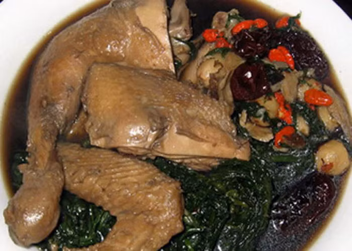 Rau ngải cứu rửa sạch, nhồi 1/2 rau ngải cứu vào bên trong con gà ác. Cho thuốc bắc vào nồi cơm điện, thêm rau ngải cứu còn lại vào cùng. Cuối cùng, cho gà ác đã ướp vào cùng, đổ ngập nước lên bề mặt gà. Bật chế độ nấu bình thường như nấu cơm là được. Ảnh: Lamchame.