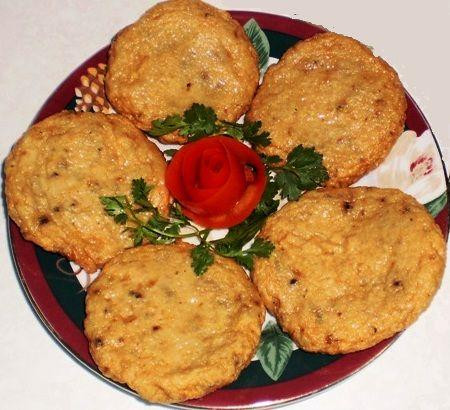 Cầm hết cá lên tay và đập xuống tô vài lần để cá được dai. Phần bột và trứng: cho bột mì, bột bắp vào tô, đập trứng vào lấy muỗng khuấy đều. Cho cá đã ướp hành, ngò cắt nhỏ nhào chung với bột. Trộn đều hỗn hợp trên. Cho ít dầu ăn thoa lên đĩa. Bắt chả cá thành từng cục và ép mỏng. Chiên chả cá với dầu nóng. Ảnh: amthuc365.com.