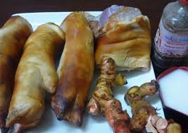 6. Móng giò nấu giả cầy. Nguyên liệu: Móng giò, mẻ, mắm tôm, hành khô, riềng, bột nghệ, hành hoa, ngổ hương (vài ngọn), hạt nêm, bột canh. Riềng rửa sạch, thái lát nhỏ rồi đem xay (giã) nát. Hành khô bóc bỏ vỏ, rửa sạch, băm nhỏ. Hành hoa, ngổ hương nhặt bỏ rễ và lá già, rửa sạch, thái nhỏ. Dùng rơm (giấy trắng) bọc xung quanh móng giò rồi đốt cho đến khi móng giò xém vàng đều các mặt và có mùi thơm. Rửa sạch lại với nước, dùng dao cạo sạch những chỗ bị xém đen, rồi chặt móng giò thành những miếng nhỏ. Ảnh: cafehepho.com.