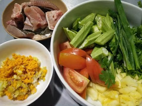 Bún cá đuối om nghệ tươi. Nguyên liệu: Cá đuối, cà chua, dứa, đậu bắp, chuối xanh, hành tím, tỏi, nghệ, dầu ăn, bột nêm, mắm, tiêu, đường, hành ngò. Cá rửa sạch, cắt quân cờ ướp với bột nêm. Phi thơm hành, tỏi, nghệ giã dập. Ảnh: cookpad.com.