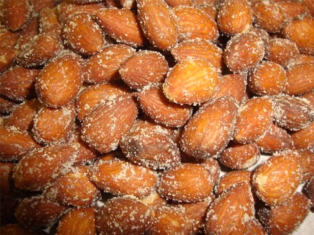 Chuẩn bị khay nướng và rắc một ít muối lên khay sau đó rắc một lớp hạnh nhân lên và lại phủ lên hạnh nhân một lớp muối khác. Rang hạnh nhân trong lò nóng khoảng từ 10 đến 12 phút hoặc đến khi hạnh nhân đã vàng thơm. Bỏ hạnh nhân ra ngoài để nguội, hạnh nhân sẽ rất giòn sau đó cất vào lọ kín bảo quản ăn dần. Ảnh: LeMart.vn.