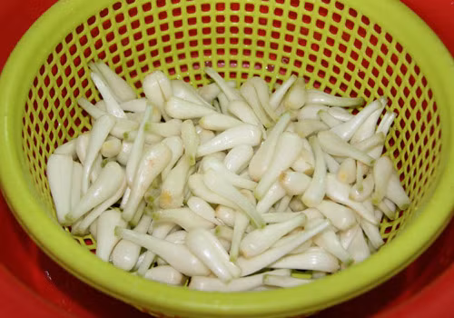 4. Củ kiệu muối chua ngọt. Nguyên liệu: Củ kiệu, cà rốt, vôi bột, đường phèn, ớt, đường trắng. Củ kiệu mua về ngâm với nước tro qua đêm rồi vớt ra để ráo nước. Tiếp tục ngâm kiệu với nước phèn chua rồi để ngoài nắng khoảng 4 tiếng. Ảnh: doisongphapluat.com.