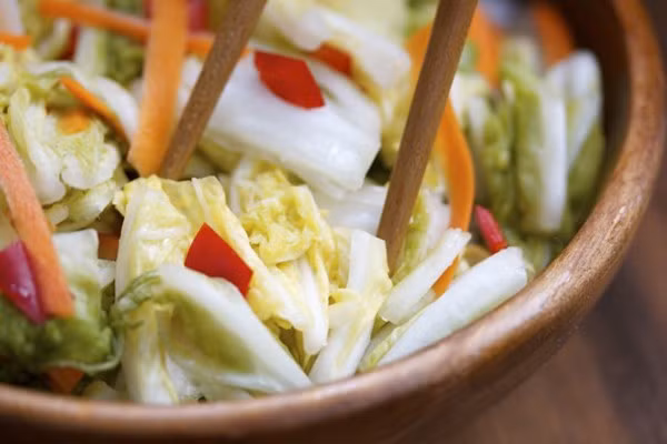 Dùng tay vắt kiệt nước cải thảo. Cho cải thảo, tỏi, gừng, tương ớt, đường trắng, giấm, hành lá vào tô, trộn đều. Cuối cùng chỉ việc cho vào hũ thủy tinh, đậy kín nắp và để nơi thoáng mát khoảng 1 ngày có thể dùng được. Ảnh: Mecuben.com.