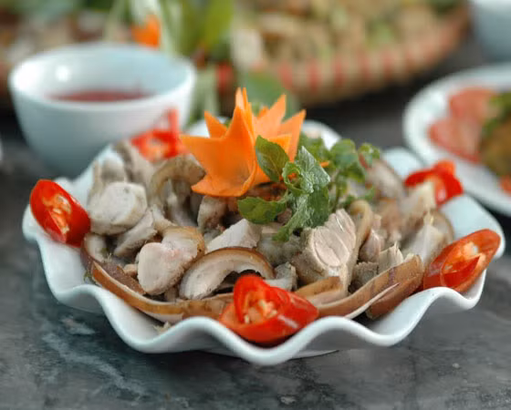 Cho thịt lên chõ hấp khoảng 30 phút. Bắc thịt ra đĩa để nguội rồi thái lát mỏng, bày thịt ra đĩa trang trí với cà rốt, rau mùi và ớt tỉa. Chuẩn bị nước chấm: Thịt lợn rừng hấp sả có thể chấm với muối tiêu chanh, tương bần hoặc nước mắm nguyên chất. Ảnh: thitlonrung.vn.