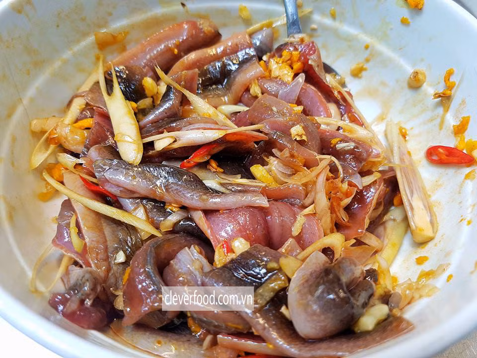 Ướp lươn với 1 gói ngũ vị hương, một ít sả, hành, gừng, tỏi băm nhỏ và một ít bột nghệ, dầu hào, hạt nêm, gia vị. Sả và ớt đã bỏ hạt đem thái vát. Cho sả, ớt và hành, gừng, tỏi băm nhỏ vào chảo đã được làm nóng cùng một ít dầu ăn, phi thơm. Ảnh: Cleverfood.com.vn.