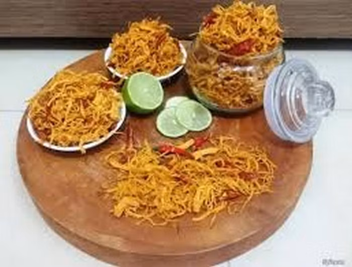 3. Khô gà xé sợi xào cay. Nguyên liệu gồm gà khô xé sợi, tỏi băm, hành tím băm, sả đập dập, tiêu, đường, mắm, muối. Bắc chảo dầu lên bếp, dầu nóng, cho khô gà xé sợi vào chiên hơi vàng thì vớt ra đĩa có lót giấy thấm dầu. Ảnh: 5giay. 