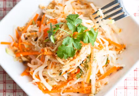 Chần su hào và cà rốt qua nước sôi để giảm bớt mùi hăng.Cho rau và tỏi vào cùng với su hào, cà rốt sau đó trộn đều. Cho thêm chanh, dấm, tỏi, ớt. Thêm lạc rang lên trên cùng và thưởng thức. Ảnh: phunutoday.vn.