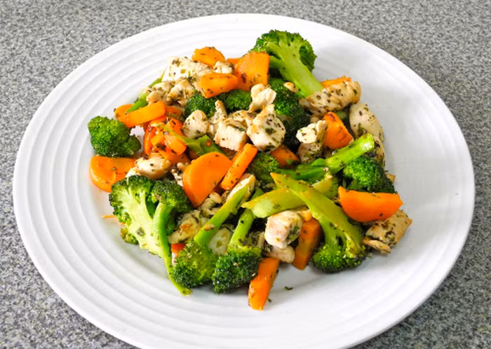 Đổ dầu vào chảo và phi thơm tỏi, sau đó thêm thịt gà vào đảo đều đến lúc nó săn lại thì thêm soups lơ và gia vị vào đảo tiếp. Đổ ra đĩa, màu sắc xanh trắng đẹ mắt của súp lơ chắc chắn khiến bé nhà bạn thèm thuồng. Ảnh: Monngonmoingay.