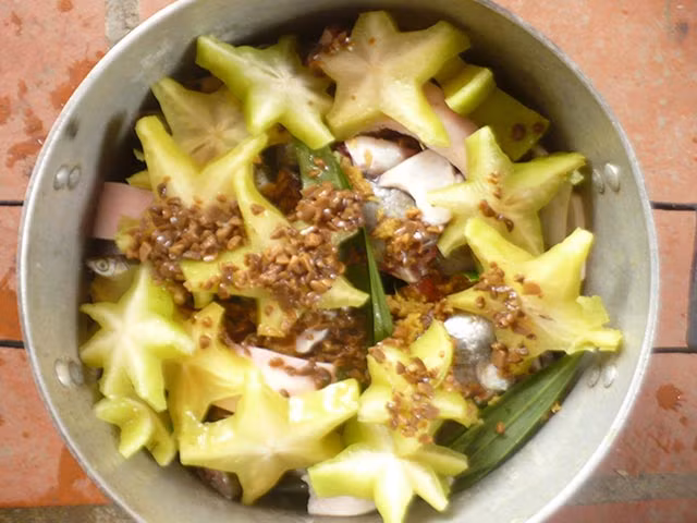 Xếp cá đã ướp vào nồi đất, phía trên xếp khế và ớt đã cắt nhỏ. Đun vừa lửa trong thời gian 5 phút cho cá ngấm gia vị, sau đó cho nước ngập mặt cá và nêm lại gia vị cho vừa miệng. Đun cá nhỏ lửa đến khi nước gần cạn thì lại bổ sung thêm 1 lần nước sôi để cá được nhừ xương. Ảnh: danviet.vn.