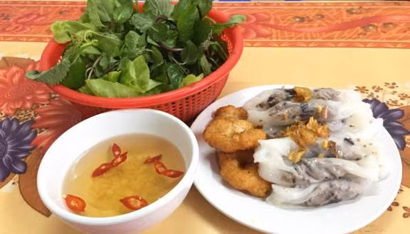 Trong khi chờ bánh chín, rắc nhân đều lên bề mặt chiếc bánh đã nguội rồi cuộn lại. Làm lần lượt cho đến khi hết nguyên liệu. Cuối cùng, cho bánh ra đĩa, thêm lần lượt chả mực và rắc đều hành phi lên trên. Thưởng thức bánh cuốn chả mực với nước chấm chua ngọt cùng các loại rau thơm rất ngon và hấp dẫn. Ảnh: Foody.vn.