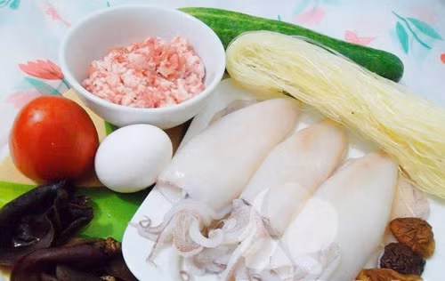 3. Mực ống nhồi thịt hấp, chiên giòn. Nguyên liệu: Mực ống, thịt lợn, trứng gà, mộc nhĩ, nấm hương, miến, bột nêm, gia vị. Mộc nhĩ, nấm hương ngâm nở, rửa sạch thái nhỏ. Cho thịt vào bát tô cùng mộc nhĩ, nấm hương, miến thái nhỏ. Ảnh: vaobepnauan.com.