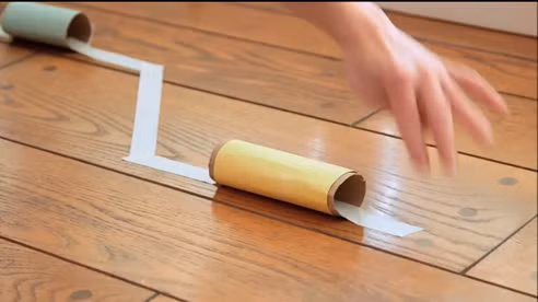 3. Trường đua kỳ thú. Chuẩn bị: Lõi cuộn giấy vệ sinh, băng giấy trắng, vài quả bóng nhựa nhỏ (có thể chui qua lõi cuộn giấy vệ sinh), ống hút. Cách chơi: Dùng băng giấy trắng dán lên sàn nhà thành một đường đua dài, giữa các băng giấy nối bằng các lõi cuộn giấy vệ sinh tạo thành các đường hầm. Ảnh: Moison.vn.