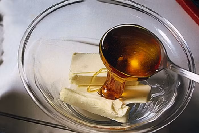 Bước 2: Đun cách thủy bơ. Khi bơ tan cho mật ong vào quấy đều. Khi bơ tan hết hãy cho sô cô la vào và khuấy để các nguyên liệu hòa quyện. Ảnh: Lamsao.