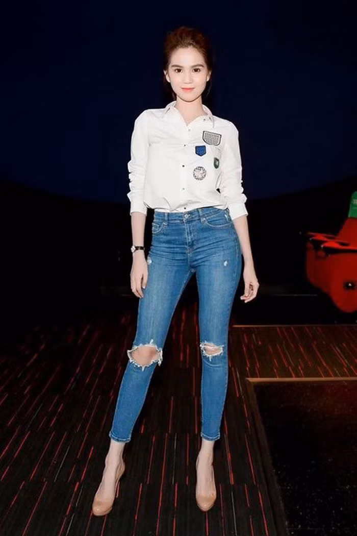 Ngọc Trinh cũng là một trong những người đẹp không nằm ngoài xu hướng này. Tuy nhiên, cô nàng tạo nên sự khác biệt trong việc phối cùng quần jeans rách là chọn chiếc áo sơ mi gắn nhiều logo trẻ trung. Ảnh: Showbiz8.
