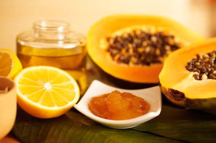 Đu đủ, chanh, mật ong. Đu đủ bỏ vỏ và hạt cho vào xay nhuyễn, thêm mật ong và nước cốt chanh rồi trộn đều lên. Khi hỗn hợp đã hòa quyện hết vào nhau thì dùng hỗn hợp này đắp đều lên da mặt. Để mặt nạ trên da trong vòng 15-20 phút rồi rửa lại thật sạch với nước ấm. Ảnh: Thammyhongngoc.