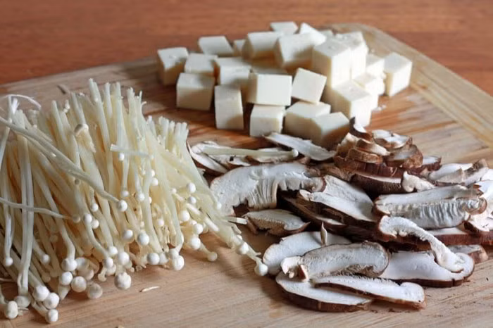 5. Đậu phụ xào nấm. Nguyên liệu gồm nấm hương, nấm rơm, nấm kim châm lượng bằng nhau, cà rốt, giá đỗ, hành mùi, ớt sừng, đậu phụ thái miếng chiên vàng. Đầu tiên ngâm các loại nấm và cắt bỏ chân rồi rửa sạch để ráo nước. Cà rốt nạo vỏ thái sợi, ớt sừng thái lát, giá đỗ nhặt rễ rửa sạch. Ảnh: Cachnauanngon.