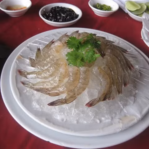 5. Tôm nhúng mù tạt. Nguyên liệu: Tôm, mù tạt, chanh, ớt, hành, xì dầu, đá bi. Tôm lột sạch vỏ, chừa đuôi, cắt bỏ lấy chỉ lưng sau đó ướp với đá bi trong vòng 10 phút. Nặn 5 quả chanh ra chén nhỏ, sau đó lấy tôm nhúng tôm để khoảng 10 phút. Ảnh: Cooky.vn.