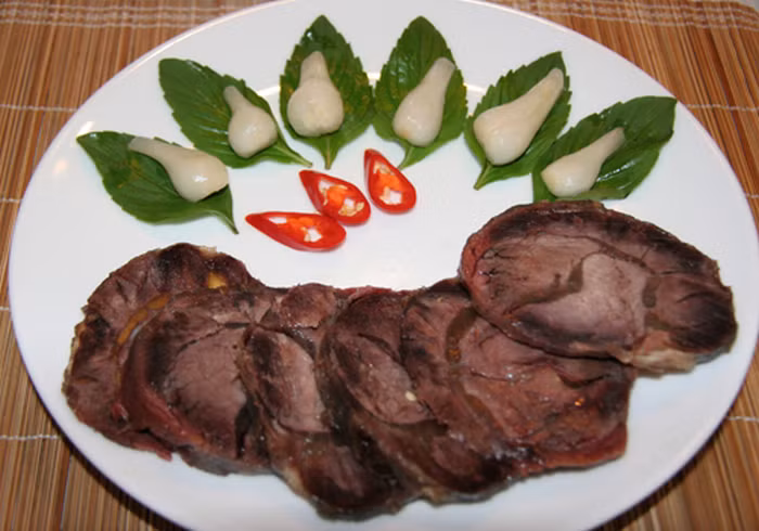 Đong nước mắm cùng với đường, dấm, nước lọc vào 1 lọ thủy tinh với tỷ lệ 2 : 2 : 1 : 1/2. Khi bắp bò thật nguội thì cho vào lọ để ngâm. Sau đó đổ hỗn hợp nước mắm đã pha vào ngập bắp bò, rồi thả nốt phần tỏi và ớt tươi vào lọ. Chèn mành tre lên trên để bò không bị nổi váng. Đậy kín lọ và ngâm bò từ 5-7 ngày là có thể dùng được. Ảnh: Monngonmoingay.