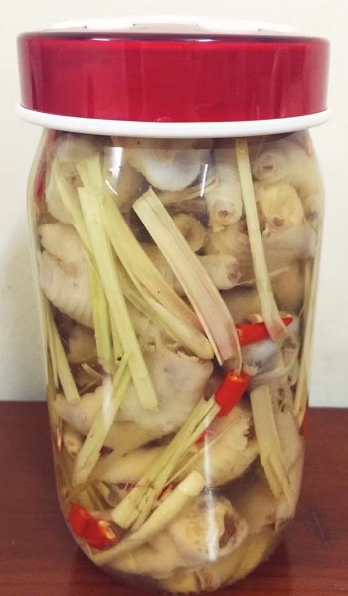 Đun sôi đường, mắm, dấm, hạt tiêu cùng nước lọc. Nêm nếm cho vừa thì tắt bếp để thật nguội. Xếp chân gà vào lọ, đổ nước ngập, thêm tiêu xanh, ớt, tỏi và chèn cho chân gà ngập nước. Muối hai ngày là ăn được. Bảo quản ngăn mát tủ lạnh để được vài tuần. Ảnh: Lamthenao.