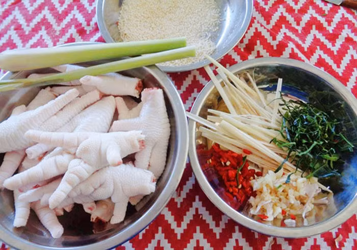 Chân gà ngâm mắm chua ngọt. Nguyên liệu gồm chân gà, nước mắm, giấm, đường, nước lọc, tiêu sọ xay thô, tiêu xanh vài nhánh, ớt tươi, tỏi, gừng đập dập. Đầu tiên cắt móng, rửa chân gà thật sạch rồi luộc chân gà cùng một chút muối và một miếng gừng. Chân gà chín tới thì vớt ra nhúng vào bát nước sôi để nguội. Ảnh: Lamthenao.