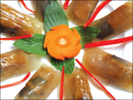 Lấy miếng lá chuối, thoa dầu vào, múc một muỗng canh bột bỏ lên lá, lấy muỗng trải bột cho có hình vuông, múc 1 muỗng nhân trải lên, sau đó kéo lá chuối bên bột không có nhân đậy lấp qua bên có nhân rồi tiếp tục cuốn lại, xong rồi bẻ 2 đầu, gấp lại, xếp vào xửng khi gói xong hết đem hấp khoảng 10 phút là bánh chín. Ảnh: me.phununet.com.