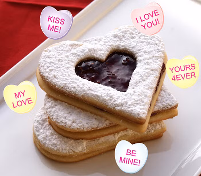 Dùng thìa để phết một lớp sô cô la (dày mỏng tùy thích) kín mặt hình trái tim. Dùng hình trái tim rỗng ruột đặt lên, ấn nhẹ tay để lớp sô cô la có thể tạo thành hình trái tim mọng. Cuối cùng là rắc bột đường xung quanh. Ảnh: ASG.