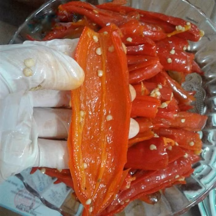 Ớt rim. Nguyên liệu gồm ớt, đường trắng, muối, dầu ăn. Ớt rửa sạch rồi cắt cuống luộc khoảng 15-20 phút. Sau đó cắt ớt bỏ hết hạt. Băm ớt cho nhừ rồi cho vào nồi, trộn cùng đường, muối, dầu ăn. Ảnh: Cooky.