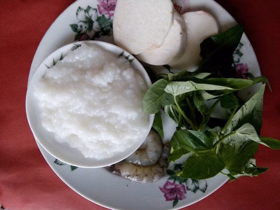 3. Cháo tôm nấu khoai sọ, rau muống: Tôm thái mỏng, phi thơm cùng hành. Khoai sọ ninh mềm, dùng thìa tán nhuyễn trộn vào cháo. Tôm và rau xay nhuyễn rồi cho tất cả vào cháo. Đun sôi thêm 5 phút rồi tắt bếp. Cho thêm thìa dầu oliu. Ảnh: FB Sao Pha Lê.