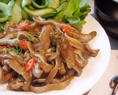 Lọc lấy 1 bát con nước luộc, khuấy cùng gia vị gồm đường, ớt, tỏi, dấm và hành hòa, rồi xuống chút bột đao để nước sánh lại, dùng làm nước sốt. Cho dạ dày vào chảo dầu chiên vàng giòn rồi cắt miếng vừa ăn, xếp lên đĩa sâu lòng theo hình đầu voi rồi thêm tai, mắt, lót thêm rau mùi, cuối cùng dội nước sốt lên trên là hoàn thành. Ảnh: niemdamme.com.vn.