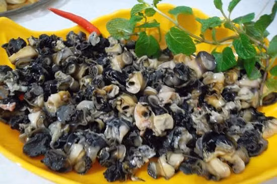 1. Ốc nấu giả baba. Đây là món ăn ngon đem lại vị giác mới lạ. Nguyên liệu: Ốc bươu to, cà chua, đậu phụ, hành, dầu ăn, mắm tôm, sườn, chuối xanh, nghệ, tỏi, mẻ, nước mắm, muối, mì chính, tía tô, hành hoa. Ốc bỏ trôn, cậy miệng khêu lấy ruột, bỏ phân. Để ruột ốc vào rổ, xát muối cho sạch nhớt, rửa lại nước lã cho thật sạch. Sườn lợn rửa sạch, chặt miếng dài khoảng 3-4cm rộng 1,5cm. Ảnh: toinayangi.vn.