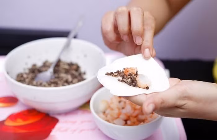 4. Bánh trôi nước nhân thịt. Nguyên liệu gồm cánh gà, chân gà, nấm hương, hành tây, hẹ, gừng, gia vị, thịt nạc, tôm, hành lá, bột nếp, bột gạo. Bỏ cánh gà và chân gà vào ninh, cho thêm cà rốt, nấm hương vào và nêm nước vừa miệng. Ảnh: Muachung.