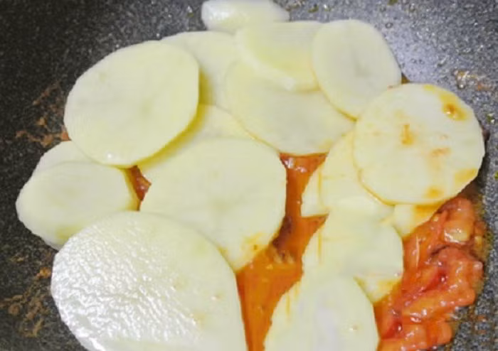 Rửa sạch khoai tây rồi luộc lên cho chín nhừ, sau đó nghiền ra cho nhuyễn mịn. Sau đó bắt lên bếp 1 cái chảo hoặc nồi, cho 1 ít dầu vào và cho khoai tây vào xào cùng với mù tạt, bột nghệ, ớt xanh và hành tây thái lát. Khuấy đều lên nấu trong khoảng 2 phút nữa thì rắc thêm 1 chút rau mùi cắt nhỏ lên trên rồi tắt bếp. Ảnh: Monngonmoingay.