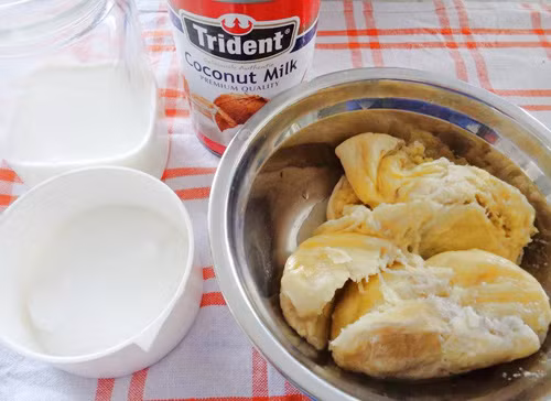 Kem sầu riêng. Nguyên liệu: Cơm sầu riêng, nước cốt dừa, sữa tươi không đường, đường cát, tinh chất vani, muối tinh. Cho nước cốt dừa và đường hòa chung trong một cái nồi nhỏ rồi cho lên bếp nấu cho đến khi nào đường tan hết thì tắt bếp. Ảnh: Eva.vn.