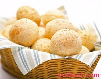 Đặt bánh vào khay nướng có lót giấy nướng, trước khi đem bánh đi nướng, lấy nửa phần trứng còn lại dùng cọ phết lớp mỏng trên mặt bánh và rắc mè đen lên. Nướng bánh ở 200 độ C trong 25 phút. Ảnh: Wikibanh.com.