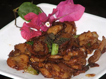 Đầu tiên đặt chảo lên bếp, có thể cho một chút dầu ăn vào sau đó cho tỏi vào phi. Tiếp theo cho thịt lợn vào chảo và rang vàng lên, khi nào thấy miếng thịt màu vàng đẹp mắt thì cho tiếp hành tây đã thái nhỏ vào đảo cùng. Tiếp theo cho mắm tôm vào và đảo đều tay cho mắm tôm hòa quyện vào thịt. Nêm một chút đường, nước mắm, bột ngọt vào chảo rồi đảo đều lên. Nên để lửa nhỏ để món ăn không bị cháy nhé. Đun khoảng 5 phút thì cho hạt tiêu và hành lá vào, đảo đều tay và tắt bếp nhé. Ảnh: bepgiadinh.com.