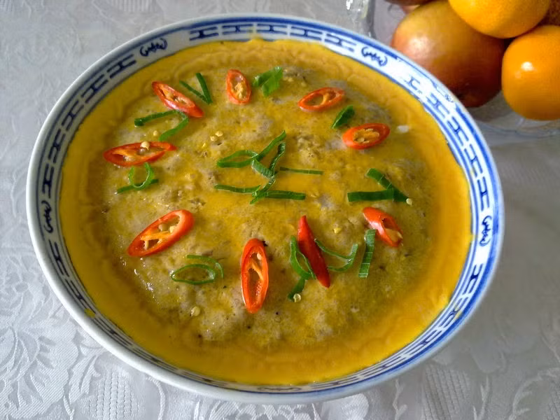 8. Mắm chưng trứng vịt. Nguyên liệu: Mắm tôm, trứng vịt, thịt heo xay, rau ăn kèm: chuối chát, khế chua, rau thơm. Đập trứng vào chén, cho mắm, thịt heo vào đánh nổi bọt. Nêm chút tiêu, bột nêm, đường vừa miệng ăn. Chưng cách thủy mắm trong nồi khoảng 20 phút. Lấy ra ăn nóng với chuối chát, khế chua, cơm trắng rất ngon. Ảnh: 2monngonmoingay.com.