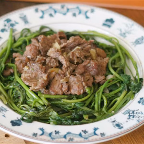 Món ngọn khoai lang xào thịt bò. Nguyên liệu: Ngọn khoai lang, thịt bò, tỏi, tiêu, dầu ăn, gia vị. Ngọn khoai lang rửa sạch. Thịt bò thái miếng mỏng vừa ăn. Ướp thịt bò với một chút tỏi, hạt nêm, tiêu và dầu ăn trong 15 phút. Làm nóng chảo với dầu ăn. Cho thịt bò vào xào lăn. Khi thịt bò chín thì lấy ra bát để riêng. Tiếp tục phi thơm tỏi trong chảo đã xào thịt bò. Cho rau lang vào xào với lửa to. Nêm chút gia vị. Khi rau vừa chín tới, trút thịt bò vào xào cùng. Đảo nhanh tay trong 2 phút, rắc thêm chút hạt tiêu lên trên. Ảnh: http://www.phunutoday.vn.