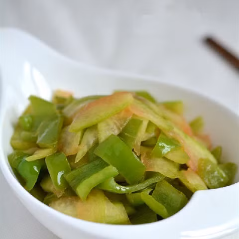 Ớt chuông xanh rửa sạch, thái miếng nhỏ vừa ăn. Làm nóng chảo dầu trên bếp, cho ớt chuông xanh vào xào. Tiếp đến cho cùi dưa vào xào, nêm muối vừa ăn xào chín tắt bếp rắc thêm tiêu cho thơm. Ảnh: Cooky.vn.