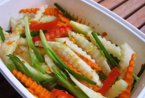 3. Cùi dưa hấu làm rau trộn. Gọt hết lớp vỏ ngoài cùng và gọt bỏ cùi riêng, rửa sạch rồi thái nhỏ thành sợi, hoặc thái thành từng miếng nhỏ. Đổ vỏ dưa vào một chiếc chậu sạch, cho một ít xì dầu, một chút muối, thêm một ít dầu thơm rồi trộn đều, rắc thêm một ít mì chính là được. Ảnh: NiemDamMe.com.vn.