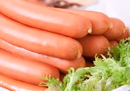 4. Món salad xúc xích. Nguyên liệu: Xúc xích, cà chua, hành tây, hành lá, ớt, nước mắm, đường, chanh, rau mùi. Xúc xích cho vào nồi nước sôi luộc trong vài phút, thái chéo xúc xích thành nhiều miếng dầy. Ảnh: doisongphapluat.vn.