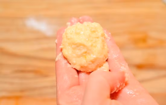 Cho đậu nành, muối và hành tây vào một cối xay nhỏ và bắt đầu xay thật nhuyễn đậu. Cho gói hương vị maggi vào hỗn hợp đậu nành hành tây và trộn thật đều lên. Cho dầu nóng, trong thời gian đợi dầu ăn sôi thì dùng muỗng múc một lượng đậu vừa đủ vào lòng bàn tay và nặn tròn như một quả bóng. Ảnh: toinayangi.vn.