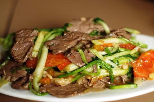 Phi thơm dầu với ít tỏi và xào thật nhanh phần thịt bò đã ướp. Sau đó cho lần lượt các nguyên liệu dưa leo, thơm và cà chua vào xào cùng. Nêm gia vị với dầu hào thêm ít phút, rắc hành tây vào đảo nhanh tay và tắt bếp. Như vậy, bạn đã có món bò xào dưa leo, thơm và cà chua thật ngon cho bữa cơm gia đình. Ảnh: 2monngonmoingay.vn.