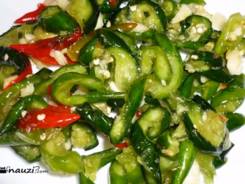 Dùng ớt, tỏi giã nhuyễn trộn với 2 muỗng cà phê nước mắm, 1 muỗng cà phê đường và vài giọt nước cốt chanh. Trộn đều dưa leo đã muối với hỗn hợp nước ướp trên cùng phần rau thơm thái sợi. Sau khoảng 1 tiếng, bạn có thể dùng. Ảnh: nauzi.com.