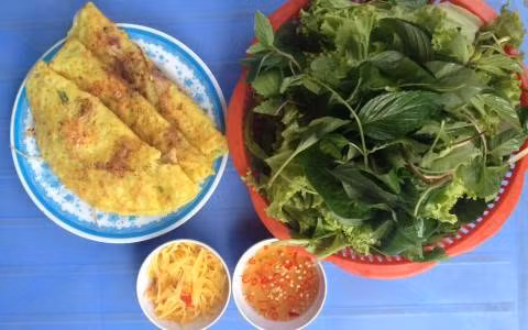 Bánh xèo miền Trung. Nguyên liệu gồm bột gạo, bột nghệ, tôm, thịt ba chỉ, nước cốt dừa, đậu xanh, cơm nguội. Đầu tiên xay nhuyễn cơm và đậu xanh rồi cho bột gạo, bột nghệ, nước cốt dừa, hành thái nhỏ và hỗn hợp xay nhuyễn cho vào khuấy đều cho hỗn hợp tan đều hết. Ảnh: Foody.