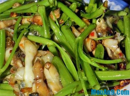 Thêm 1 ít gia vị vào ốc trộn lên. Nhặt rau, rửa sạch. Tỏi băm nhỏ. Phi thơm tỏi, cho rau vào, nêm bột ngọt, muối. Cho ốc vào đảo đều khoảng 3 phút rồi cho 1 muỗng đường. Cho tiêu vào và tắt bếp. Đây là một trong những món ngon từ rau muống rất hấp dẫn, đưa cơm. Ảnh: monan9.com.
