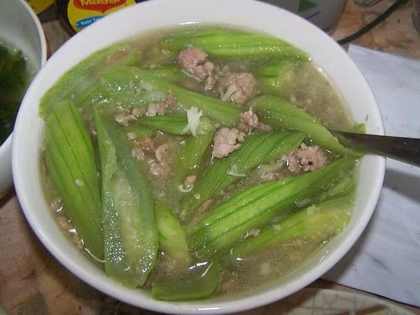 Bỏ mướp hương vào cùng thịt xào trong 2 phút, nêm chút gia vị (bột nêm) cho vừa khẩu vị. Đổ 5 bát nước (lượng vừa đủ), vặn to lửa đun sôi canh. Để nhỏ lửa đun trong 5 phút cuối cùng nêm gia vị vừa ăn.